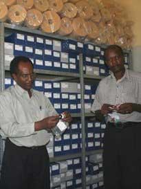 Mr. Longini Mtalo and Mr. Ingi Mayo arranging the shelf